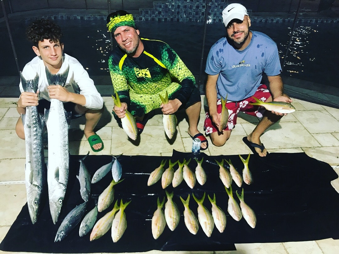 Fishing charter guests with a full catch of yellowtail snapper and kingfish — Mako 30ft Miami