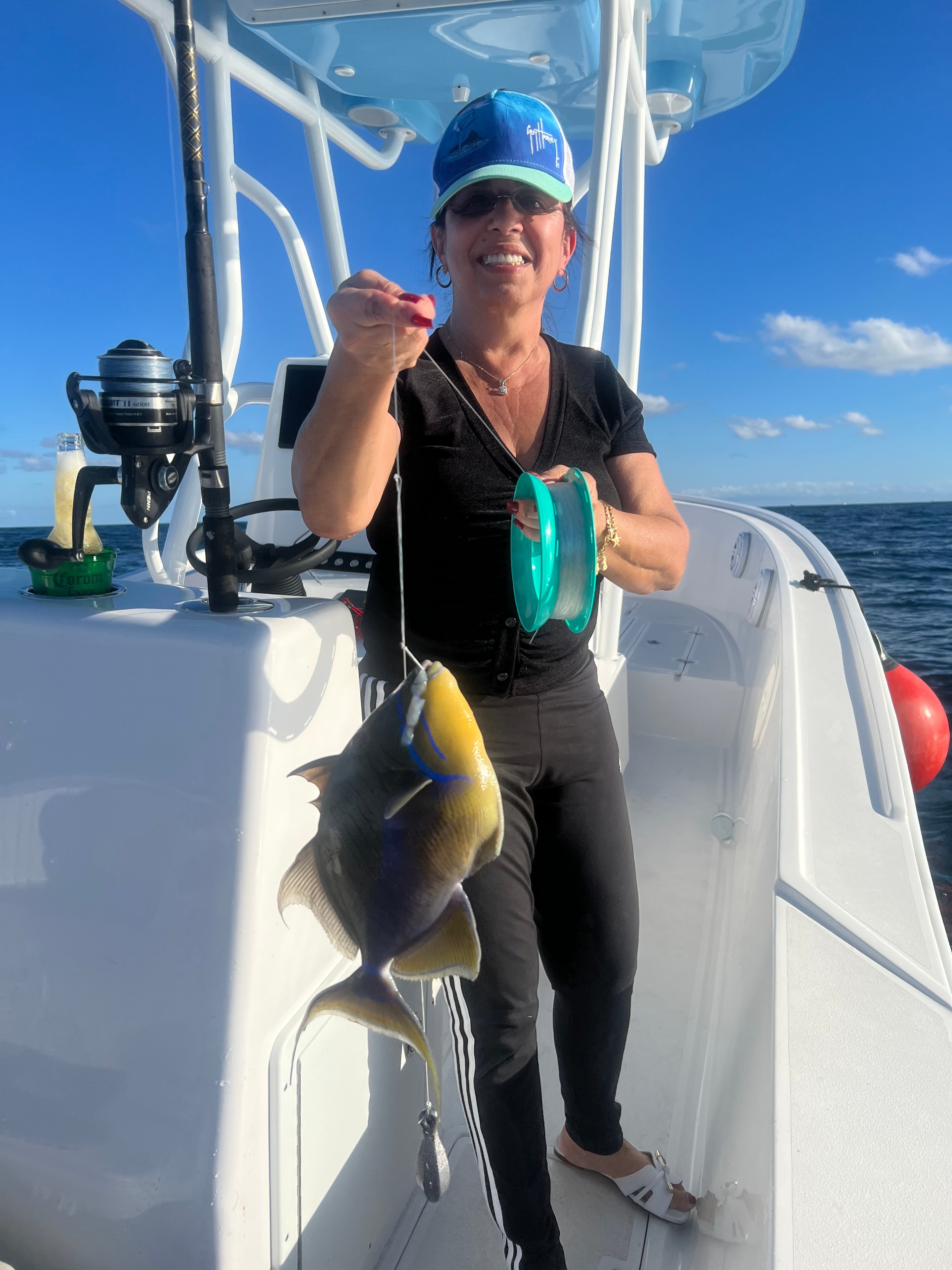 Lady angler with a queen triggerfish caught aboard the Mako 30ft Center Console Miami