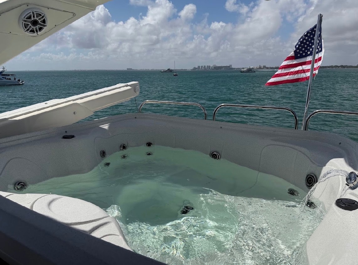 Sunseeker 88ft on-deck jacuzzi with American flag and Biscayne Bay views — yacht with jacuzzi Miami